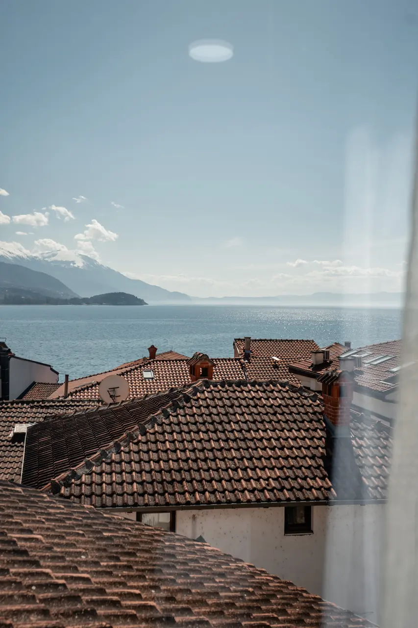 Roofs, lake and mountains from the window, portrait